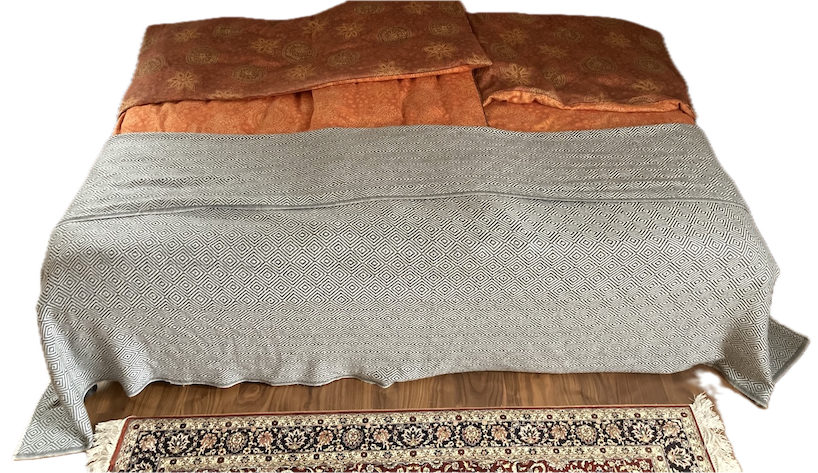 Kaschmir-Tagesdecke „Talseite“ auf einem Bett